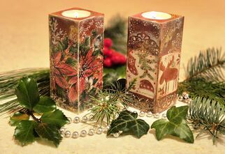 Zdjęcie: Dwa świeczniki wykonane techniką decoupage z bożonarodzeniowymi akcentami z palącymi się na górze tealight'ami stojące na elementach z igliwia, listków i sznurka z białych koralików