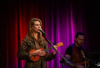 Zdjęcie: młoda kobieta śpiewająca i grająca na ukulele