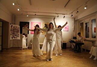 Zdjęcie: grupa osób w białych strojach z podniesionymi rękami