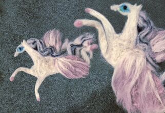 Zdjęcie: Konie z filcu w biało-różowej kolorystyce na zielonym tle
