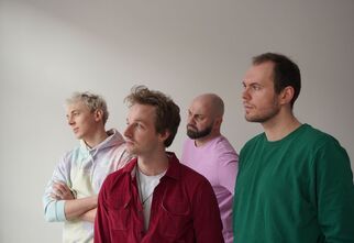 Zdjęcie: Czterech mężczyzn w średnim wieku patrzących w jedną stronę