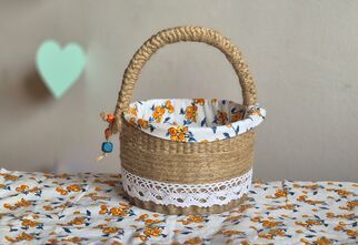 Zdjęcie: Koszyczek z juty z koronką na kolorowym obrusie wyściełany kolorowym materiałem