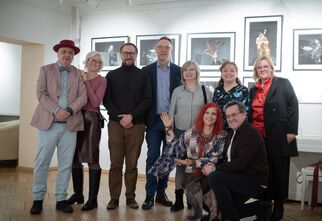 Zdjęcie: grupa uśmiechniętych osób na tle zdjęć