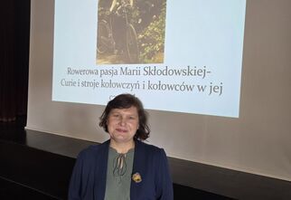 Zdjęcie kobiety w średnim wieku na tle prezentacji z wykładu