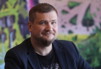 Zdjęcie: mężczyzna w średnim wieku z zarostem w ciemnej marynarce