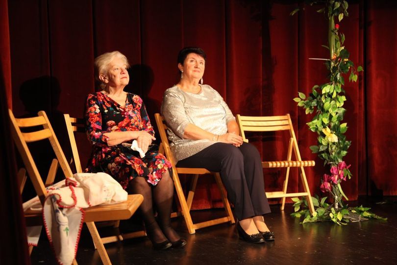 Dwie kobiety siedzą na krzesłach na scenie