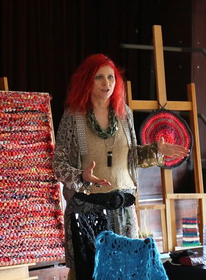 Dorota Koch stoi obok tkaniny zrobionej na szydełku.