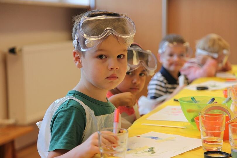 Dzieci na warsztatach Małych Einsteinów z materiałami do wykonywania eksperymentów