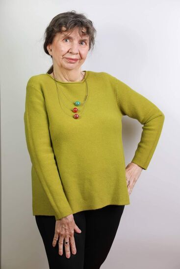Stojąca kobieta w średnim wieku w żółtej bluzce