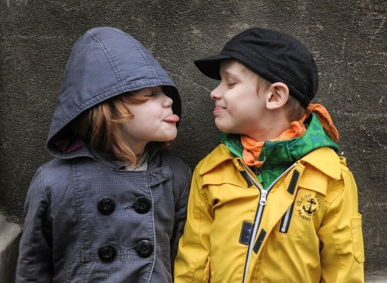 Dziewczynka i chłopiec pokazują sobie język