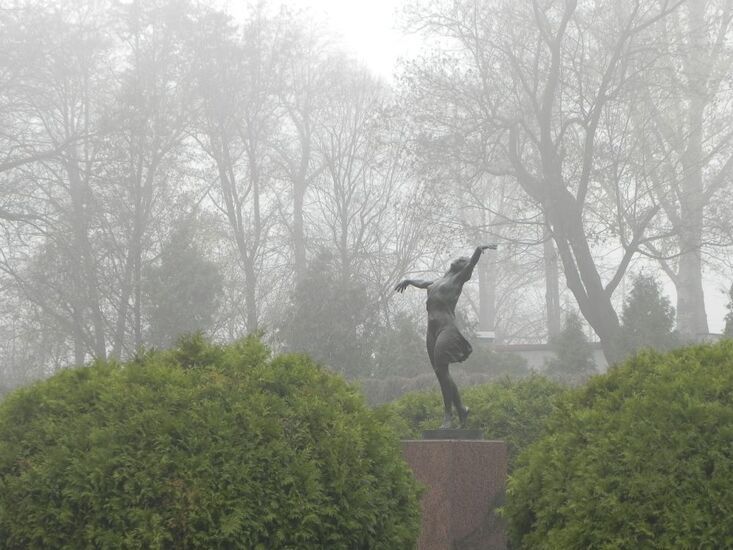 Pomnik taczącej kobiety w parku.