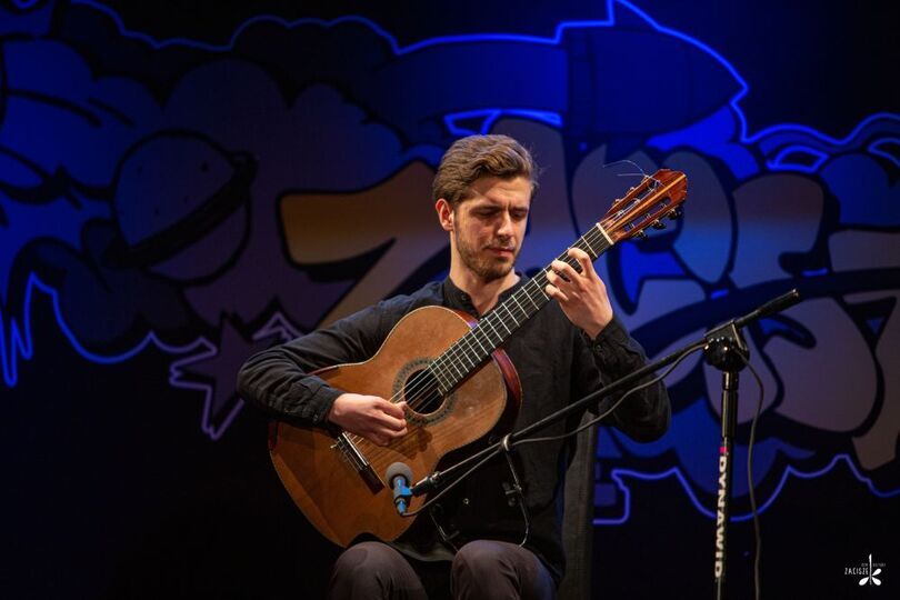 Radosław Michałek podczas gry na gitarze.