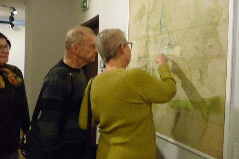 Kobieta w żółty sweterku i mężczyzna w granatowym patrzą na mapę