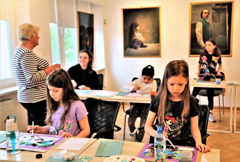 Dzieci i instruktorka podczas zajęć artystycznych