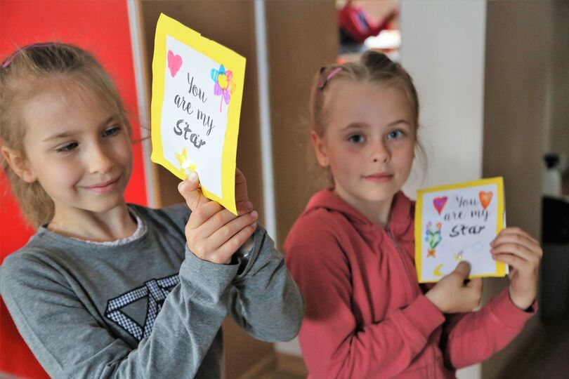 Dziewczynki prezentujące swoje kartki na Dzień Matki