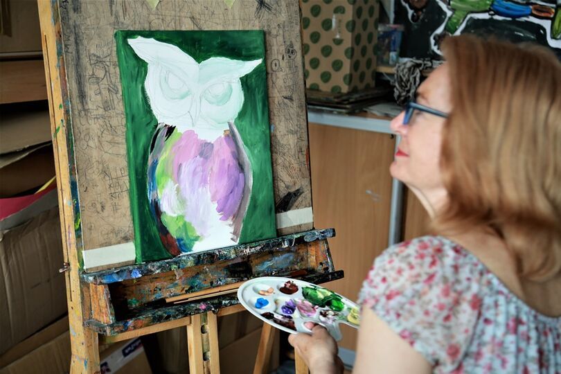 Kobieta malująca sowę na płótnie