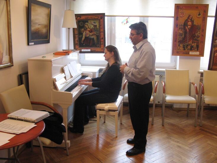 Zdjęcie: kobieta gra na pianinie, mężczyzna stoi i śpiewa
