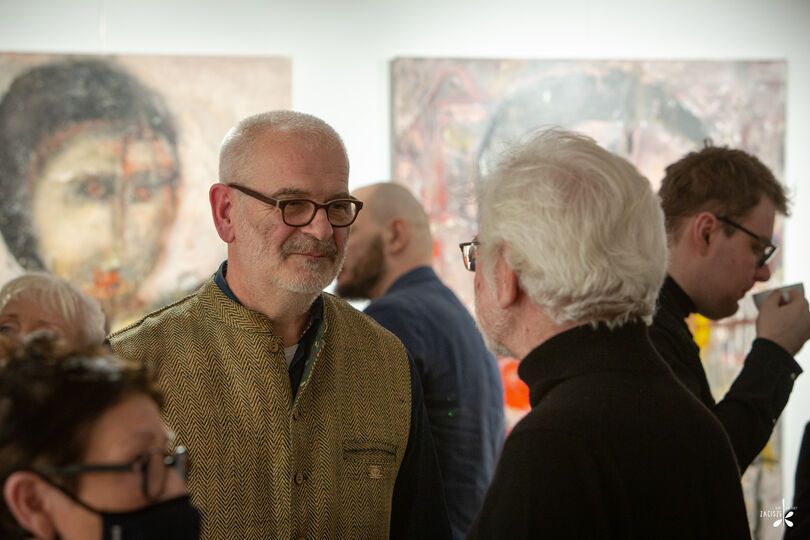 Artysta rozmawiający z ludźmi odwiedzającymi galerię