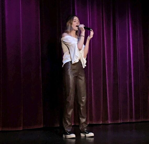 Dziewczyna śpiewająca przez mikrofon na scenie
