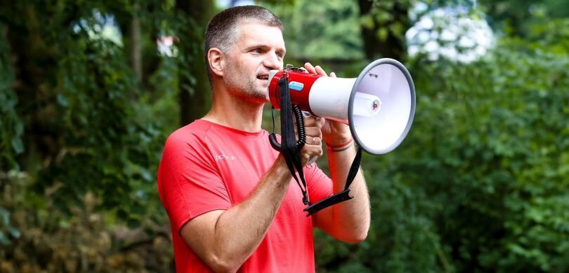 Mężczyzna w czerwonej koszulce z megafonem