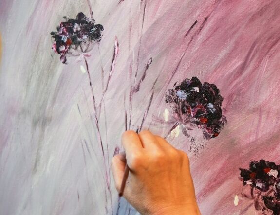 Ręka z pędzlem malująca kwiaty