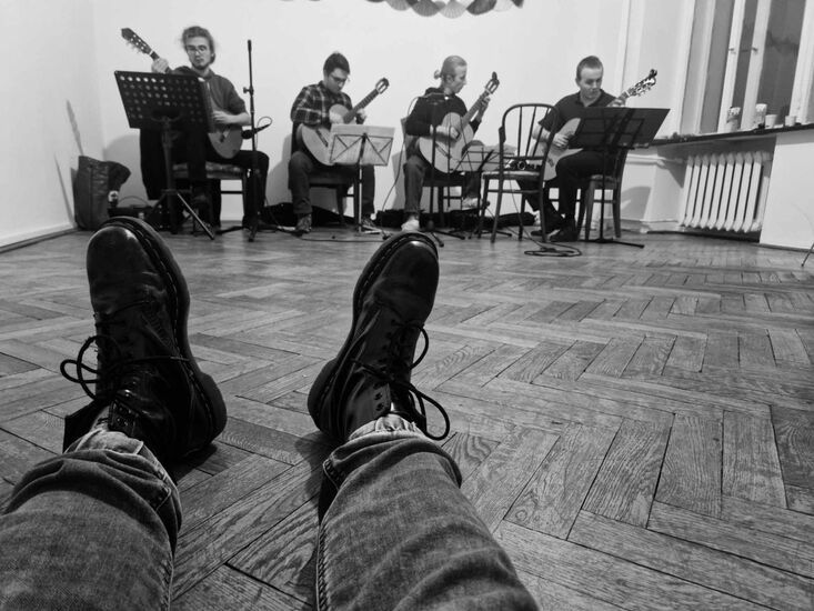 Foto Glany na męskich stopach,  w tle czterech muzyków