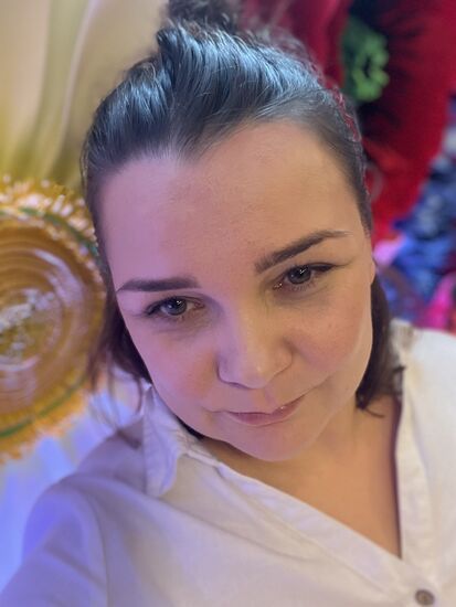 Zdjęcie: brunetka w średnim wieku, lekko uśmiechnięta, w białej koszuli