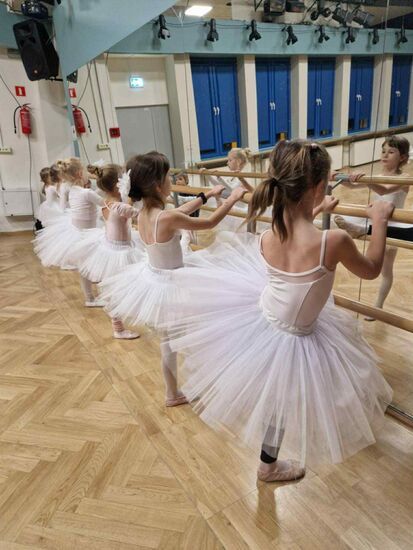 Zdjęcie: sześć dziewczynek w różowych spódniczkach w pozycji przy drążku