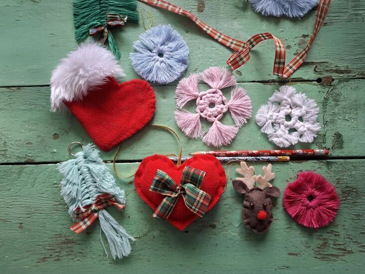 Zdjęcie: na drewnianym podłożu kolorowe ozdoby ręcznie uszyte, gwizdki, serce, rudolf, but mikołaja