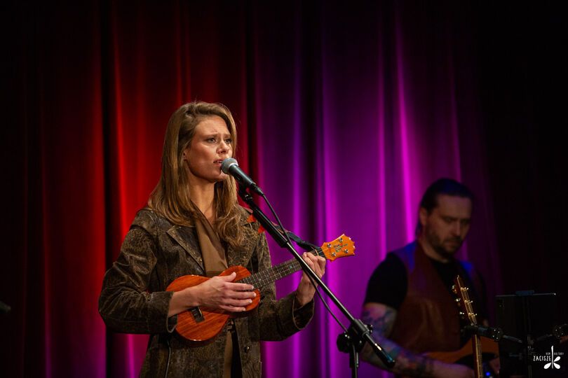 Zdjęcie: młoda kobieta śpiewająca i grająca na ukulele