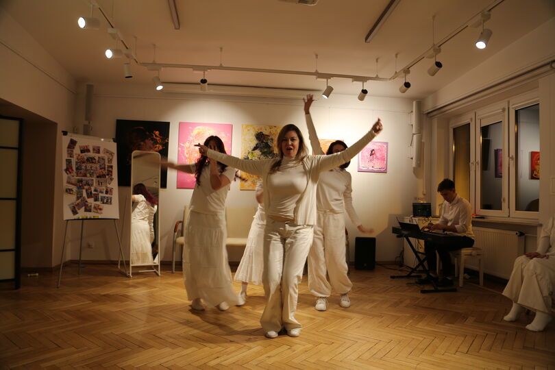 Zdjęcie: grupa osób w białych strojach z podniesionymi rękami