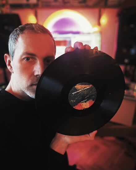 Zdjęcie: Mężczyzna w średnim wieku, trzymający płytę winylową