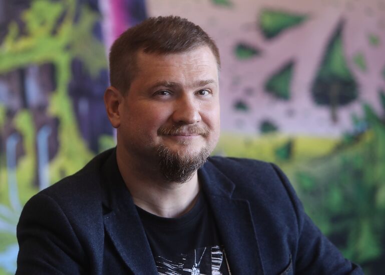 Zdjęcie: mężczyzna w średnim wieku z zarostem w ciemnej marynarce