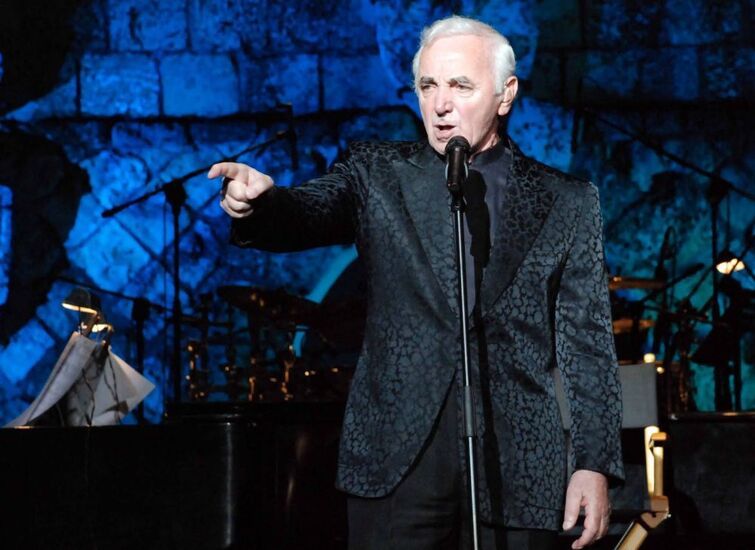 Zdjęcie starszego człowieka z podniesioną ręką, foto: https://jazzforum.com.pl/main/news/charles-aznavour-po-blisko-30-latach-znowu-w-polsce