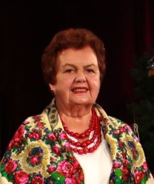 Zdjęcie kobiety w wieku senioralnym, w czerwonych koralach i kolorowej chuście